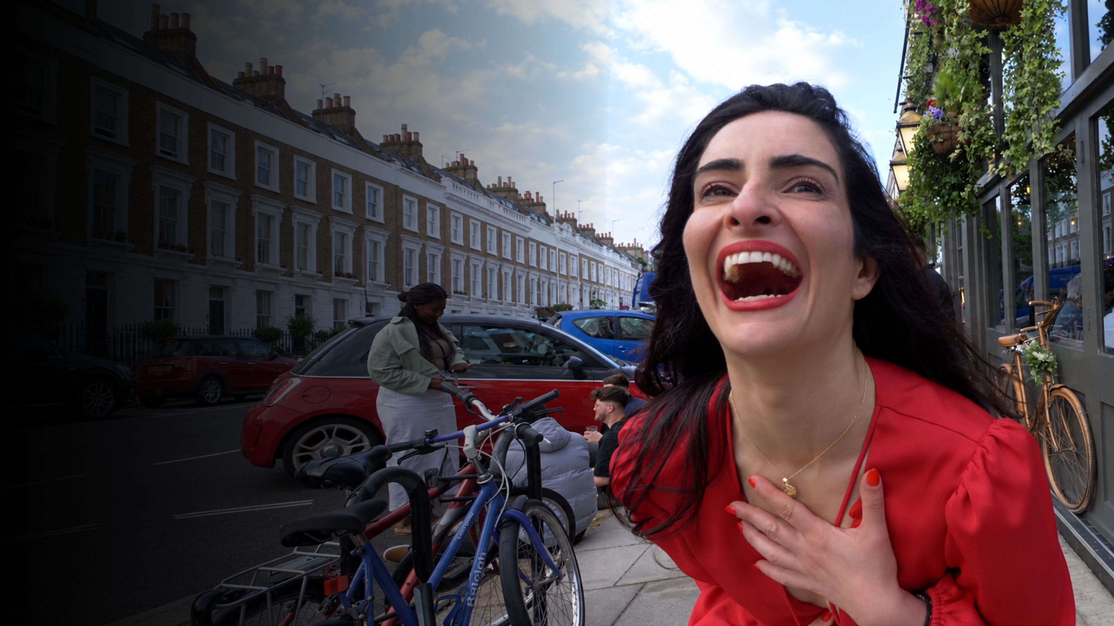 Woman in a red dress laughing on a London street