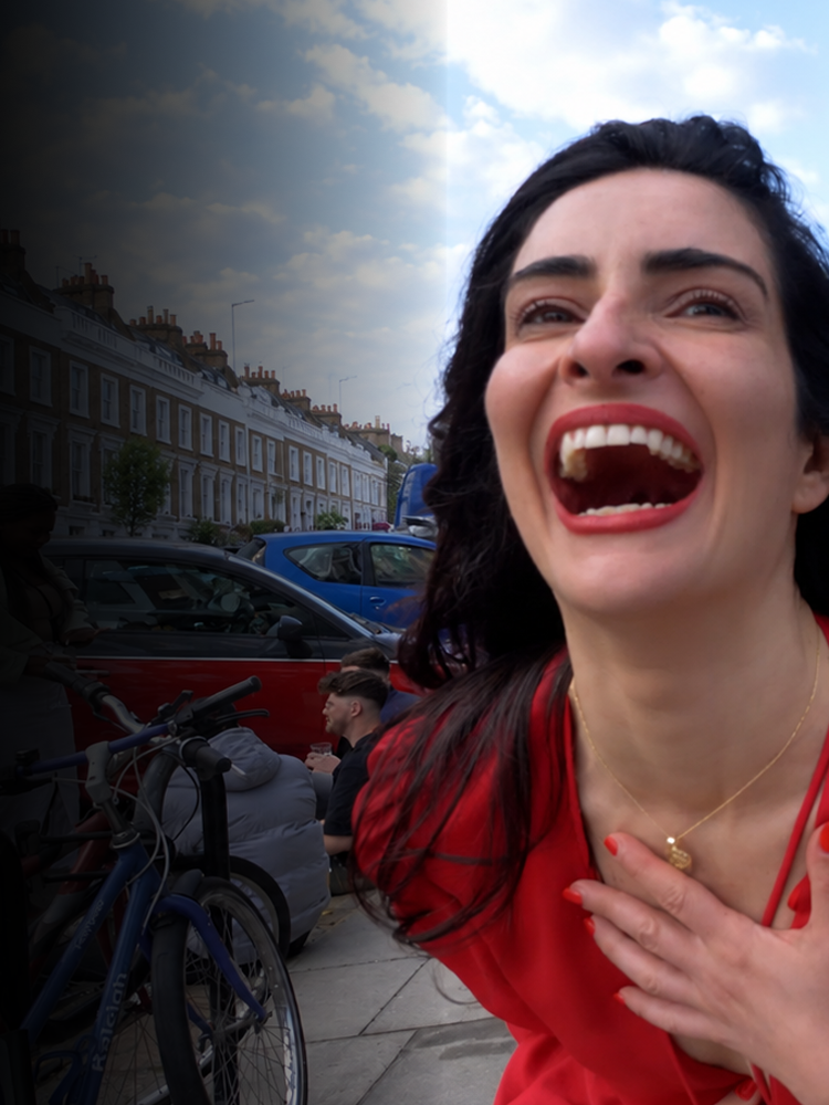 Woman in a red dress laughing on a London street